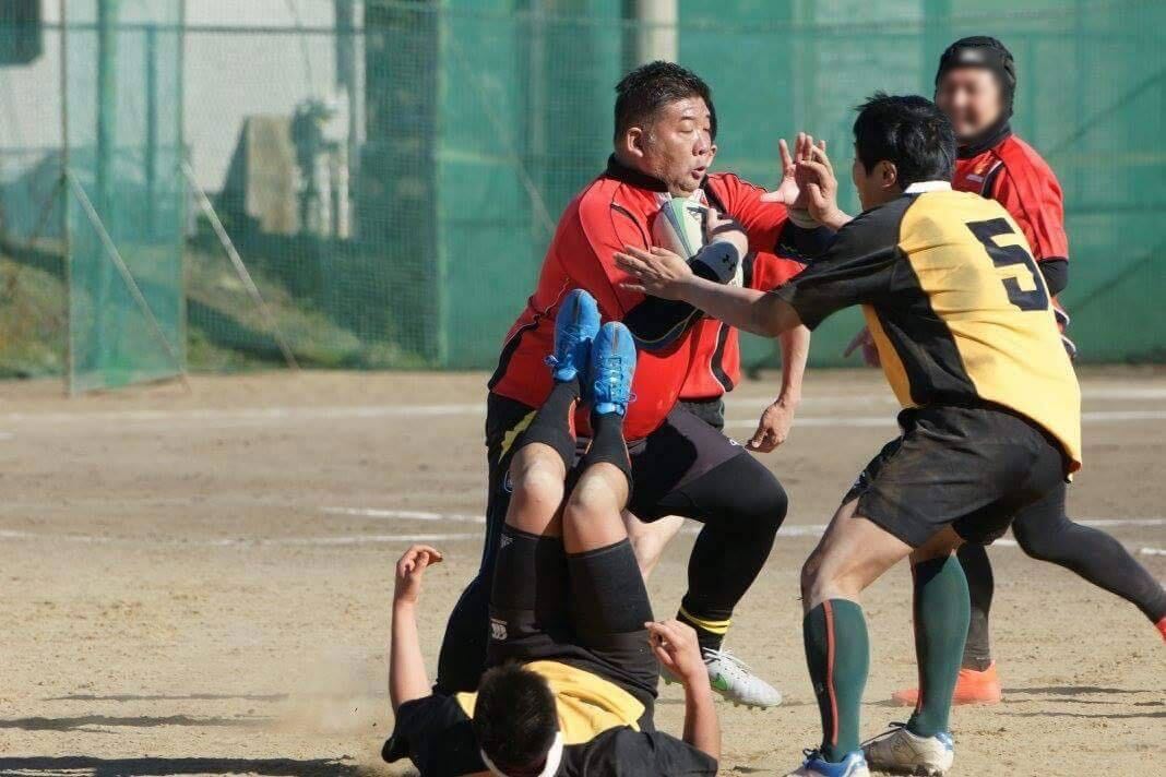 ラグビーの練習で子どもたちと組み合う原 正紀